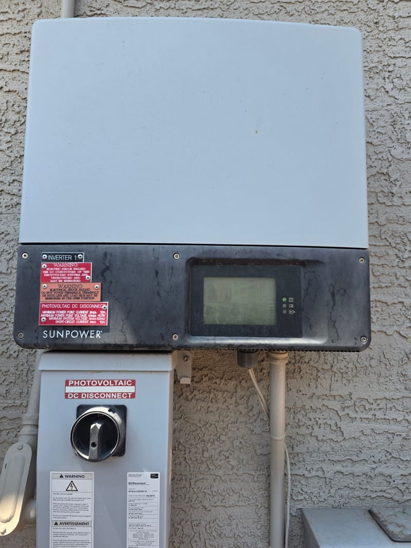 Solar inverter and photovoltaic DC disconnect mounted on a stucco wall